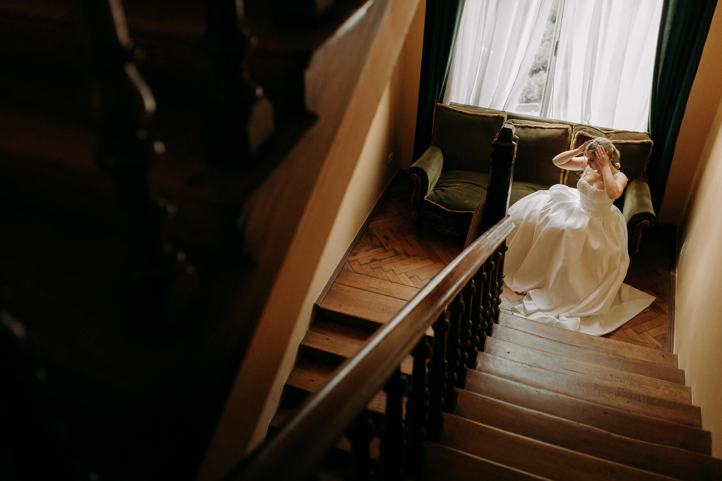 Ślub cywilny w plenerze Pałac Żeleńskich Grodkowice panna młoda siedzi na kanapie przy zabytkowych schodach