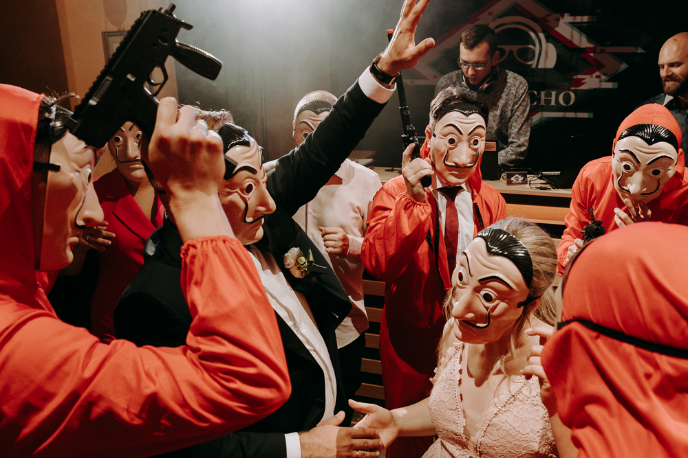 Ślub cywilny w plenerze Pałac Żeleńskich Grodkowice goście i para młoda tańczą w przepraniach z serialu Dom z papieru