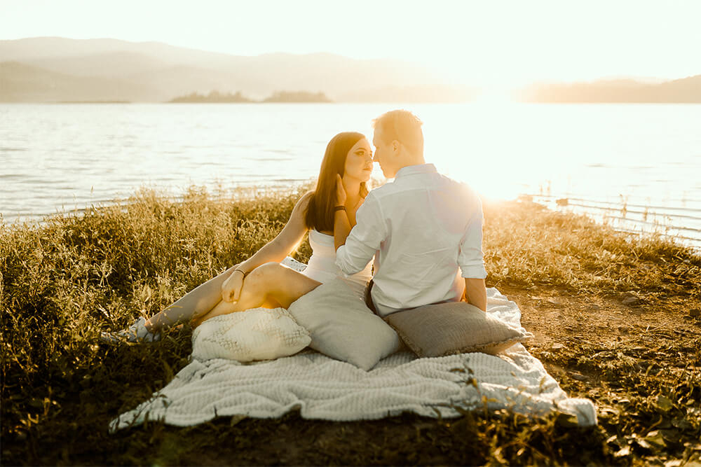Sesja narzeczeńska w plenerze nad Jeziorem Mucharskim zakochani kobieta i mężczyzna zapatrzeni w siebie intymność