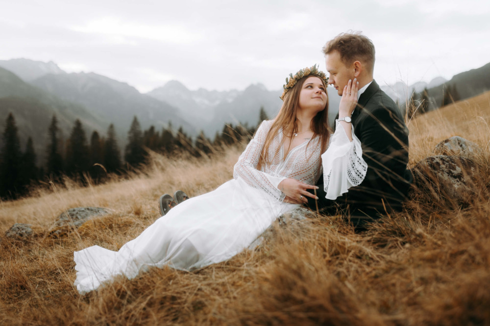 Zakochani leżą w trawie podczas sesji ślubnej w Tatrach.