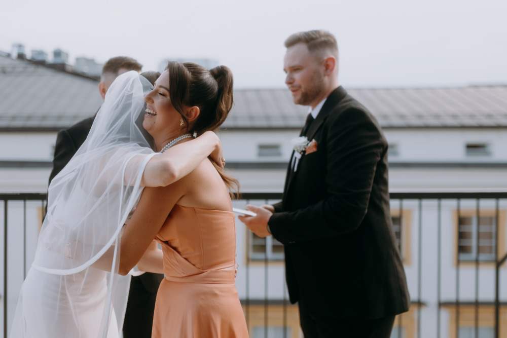 Uścisk panny młodej z druhną, radosny moment, fotograf ślubny Kraków.