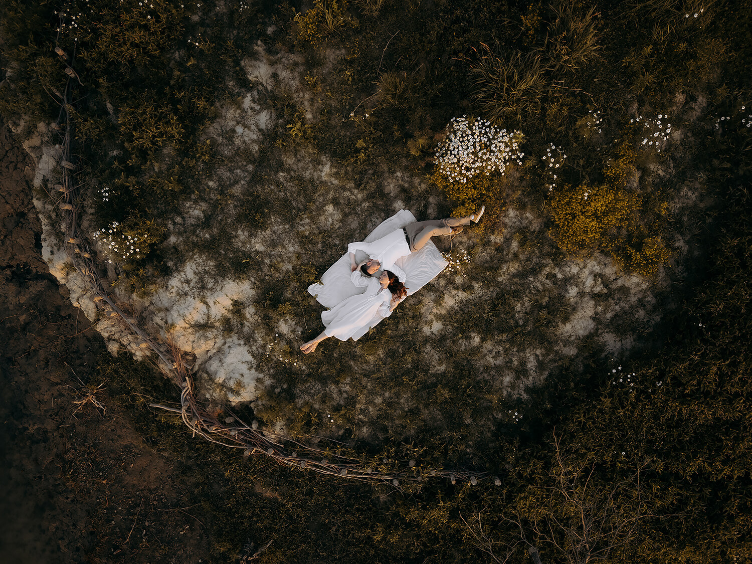 Zakochana para leży na kocu wśród traw i kwiatów, Jezioro Mucharskie, sesja.
