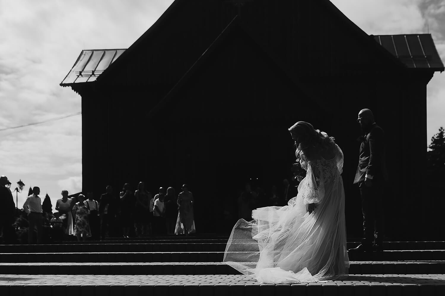 Para młoda wychodzi z kościoła. Czarno-biała fotografia ślubna.